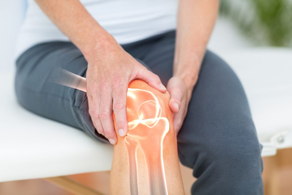 Close-up of a person holding their knee, highlighting joint pain and inflammation, commonly associated with arthritis. The image visually represents arthritis symptoms, such as stiffness and discomfort, potentially caused by rheumatoid arthritis, psoriatic arthritis, or septic arthritis. It emphasizes the impact of arthritis in joints and the need for effective arthritis treatment options for improved mobility and pain relief