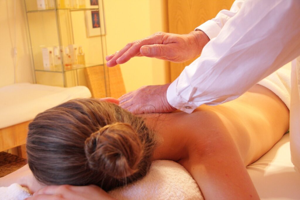 A woman in arthritis pain is lying on a massage table having a massage